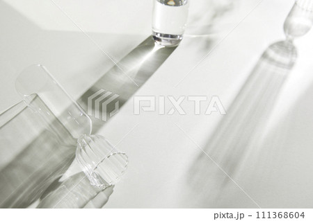 Natural texture of various glass cups on a table with sunlight streaming in. Natural texture of various glass cups on a table with sunlight streaming in. 111368604