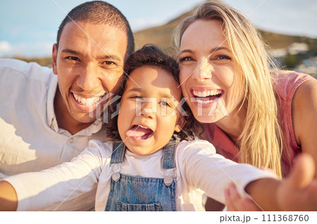 Face selfie, comic and funny happy family on a trip, vacation or holiday outdoors. Portrait, love and caring mother, father and child together at beach taking pictures spending free time bonding. 111368760