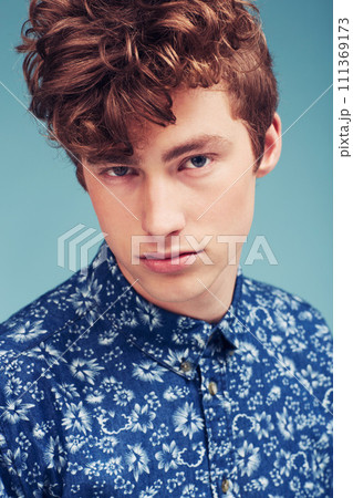 Fashion, serious and portrait of man on blue background in trendy shirt, stylish outfit and casual clothes. Aesthetic, attractive model and face of person with confidence, pride and style in studio 111369173