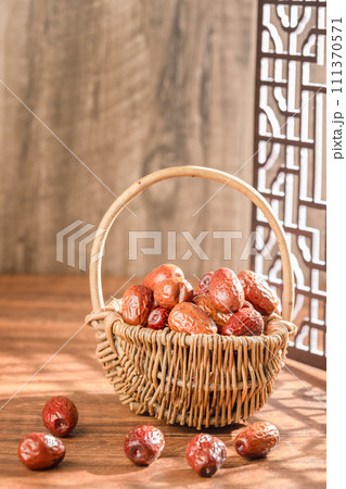 Dates in basket on wooden table 111370571