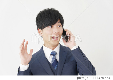 驚きながらスマートフォンで電話するビジネスマン　白背景 111370773