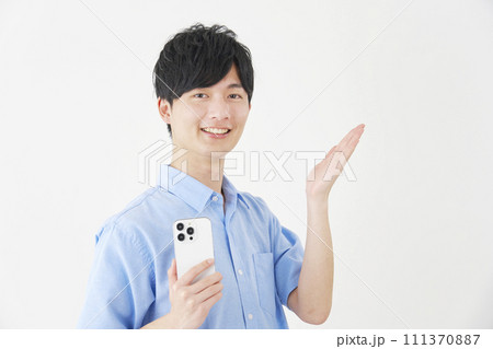 スマートフォンを持って手の平で右を指す男性 白背景 スマートフォンを持って手の平で右を指す男性 白背景 111370887