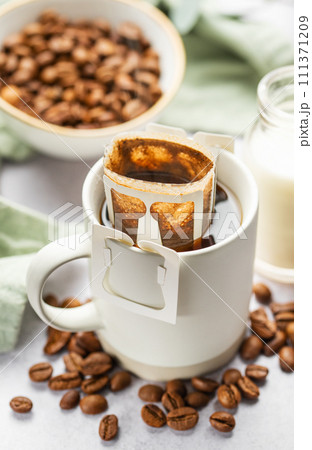 Drip coffee bag with ground coffee in cup Drip coffee bag with ground coffee in cup 111371209