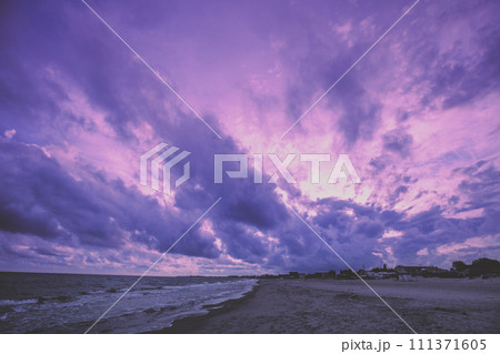 Early morning on the beach. Pink purple sunrise over the sea. Pastel color Early morning on the beach. Pink purple sunrise over the sea. Pastel color 111371605