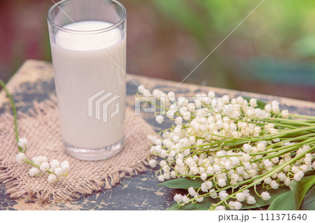Glass of milk on grunge wooden table outdoors 111371640