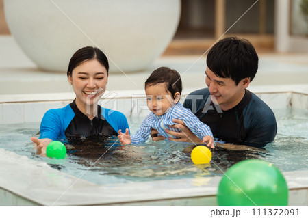 happy family. father and mother with small daughter in swimming pool. 111372091