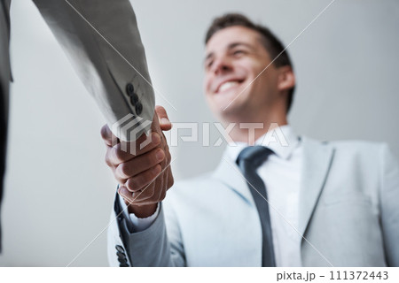 Low angle, businessman and shaking hands with partner, colleague and smile for deal or promotion. Man, consult and hand for contract agreement, interview and advice for agency and office partnership 111372443
