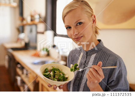 Woman, portrait and salad eating in kitchen or health nutrition for wellbeing, ingredients or fibre. Female person, face and bowl or vegetable meal in apartment for diet leafy greens, food or Canada Woman, portrait and salad eating in kitchen or health nutrition for wellbeing, ingredients or fibre. Female person, face and bowl or vegetable meal in apartment for diet leafy greens, food or Canada 111372535