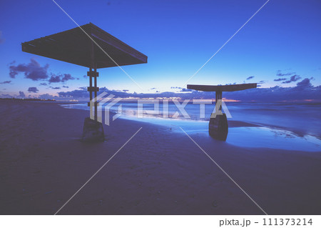 Sunshades on the evening beach after sunset. Seascape at night. Caesarea, Israel 111373214