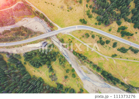 Aerial view of the mountains in autumn. The winding road along the river. Beautiful nature landscape. Bridge over the Prut River near Tatariv village, Carpathian mountains. Ukraine Aerial view of the mountains in autumn. The winding road along the river. Beautiful nature landscape. Bridge over the Prut River near Tatariv village, Carpathian mountains. Ukraine 111373276