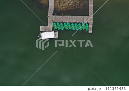 Aerial view of a lake boat dock. Flying above a vessel pier Aerial view of a lake boat dock. Flying above a vessel pier 111373428