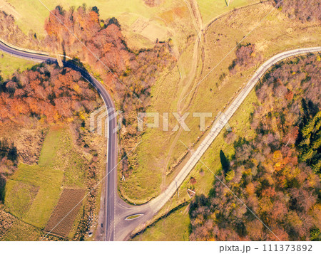 Crossroads on a winding highway in the autumn mountains. View from the drone. Beautiful natural landscape. Carpathians. Ukraine 111373892