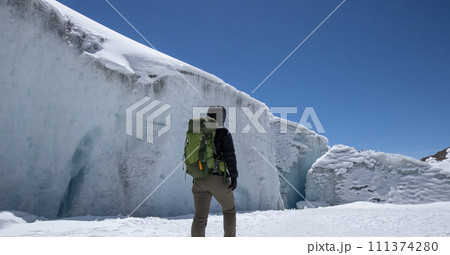 Woman hiker hiking in winter huge glacier mountain,China 111374280