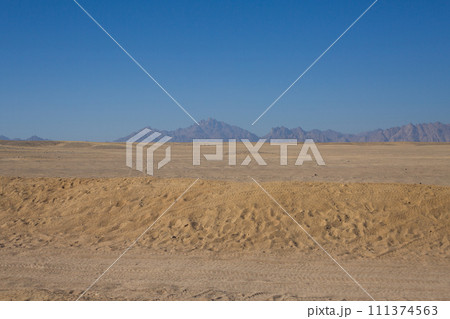 Endless desert tire marks on sand 111374563