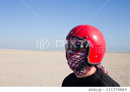 Portrait of man in helmet and keffiyeh in desert 111374664