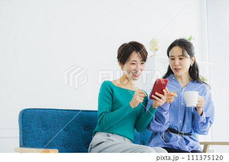 スマホを見る2人の女性 111375120
