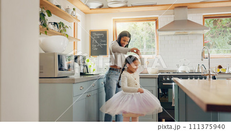 Dance, ballet and girl with mother in a kitchen together or mom support child and playing as a dancer or ballerina. Tutu skirt, mommy and woman dancing, bonding or spin with kid in house or home 111375940