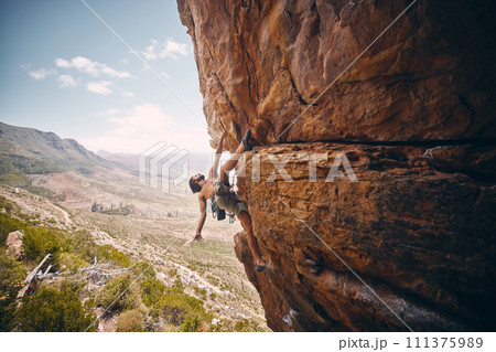 Rock climbing, rope and fearless mountain climber on a cliff, big rocks and risky challenge alone in summer. Mountaineering, bouldering and strong man training his body for balance outdoors in nature Rock climbing, rope and fearless mountain climber on a cliff, big rocks and risky challenge alone in summer. Mountaineering, bouldering and strong man training his body for balance outdoors in nature 111375989