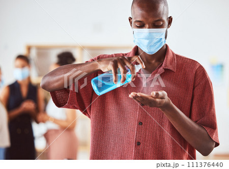 Covid, hand sanitizer and business man with face mask at business meeting for healthcare safety, risk management and compliance. Covid 19, corona virus and policy black man with spray bottle cleaning Covid, hand sanitizer and business man with face mask at business meeting for healthcare safety, risk management and compliance. Covid 19, corona virus and policy black man with spray bottle cleaning 111376440
