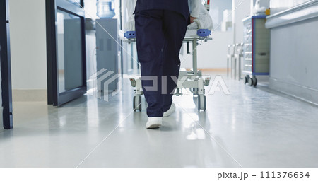 Nurse, feet and walking patient in hospital, bed or steps in hallway or corridor to surgery, operation room or ER healthcare. Doctor, moving and pushing person in clinic to ICU, bedroom or walk Nurse, feet and walking patient in hospital, bed or steps in hallway or corridor to surgery, operation room or ER healthcare. Doctor, moving and pushing person in clinic to ICU, bedroom or walk 111376634