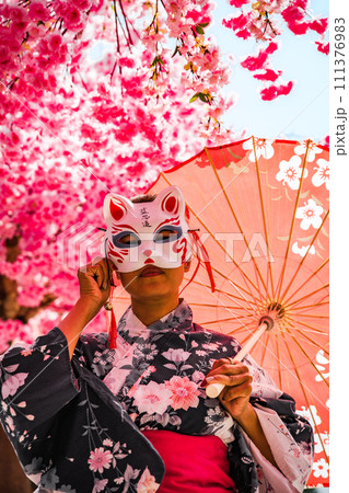 Asian girl in kimono and umbrella in Japanese theme park Hinoki Land in Chai Prakan District, Chiang Asian girl in kimono and umbrella in Japanese theme park Hinoki Land in Chai Prakan District, Chiang 111376983