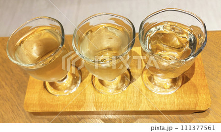 ガラスのお猪口に入った日本酒を飲み比べ ガラスのお猪口に入った日本酒を飲み比べ 111377561