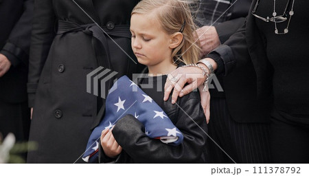 Funeral, cemetery and girl with American flag for veteran for respect, ceremony and memorial service. Family, depression and sad child by coffin in graveyard mourning military, army and soldier hero Funeral, cemetery and girl with American flag for veteran for respect, ceremony and memorial service. Family, depression and sad child by coffin in graveyard mourning military, army and soldier hero 111378792
