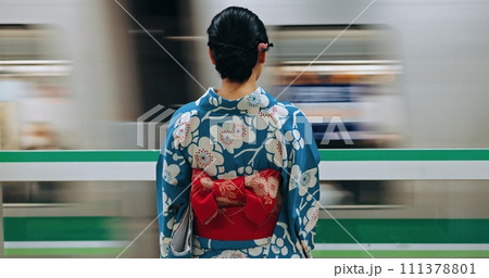 Japan woman, travel and train station in kimono and public transportation on metro bullet in city. Person, motion blur or traditional clothes by fast vehicle or subway in tokyo on urban adventure 111378801