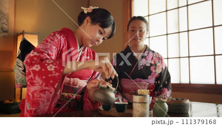Japanese, friends or kimono for tea ceremony in Chashitsu with peace or custom tradition. Women, temae or vintage style dress or conversation with culture, fashion or honor with antique crockery 111379168