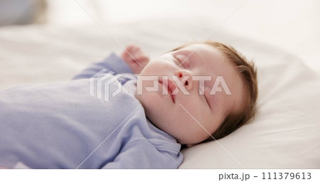 Relax, growth and sleep with a baby in a bedroom closeup in a home, dreaming during a nap for child development. Kids, calm and rest with an adorable newborn infant asleep on a bed for comfort Relax, growth and sleep with a baby in a bedroom closeup in a home, dreaming during a nap for child development. Kids, calm and rest with an adorable newborn infant asleep on a bed for comfort 111379613