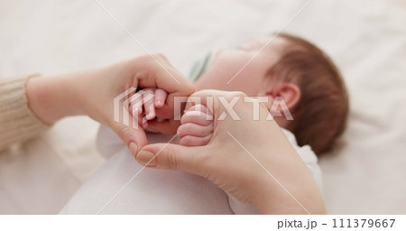 Bed, holding hands and mother with baby, love and support for care, health and wellness at home. Fingers, family or mama with a healthy infant, protection and child development with bond or maternity 111379667