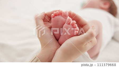 Feet, hands and mother with baby, love and support for care, health and wellness in bedroom. Closeup, family or mama with an infant, protection and child development with bonding or maternity in home 111379668