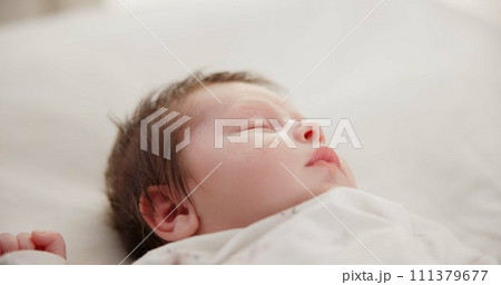 Baby, face and sleeping in the morning on nursery bed and blanket with nap and rest. Relax, calm and tired newborn with youth on bedding with kid sleeping from above in a family home and bedroom Baby, face and sleeping in the morning on nursery bed and blanket with nap and rest. Relax, calm and tired newborn with youth on bedding with kid sleeping from above in a family home and bedroom 111379677