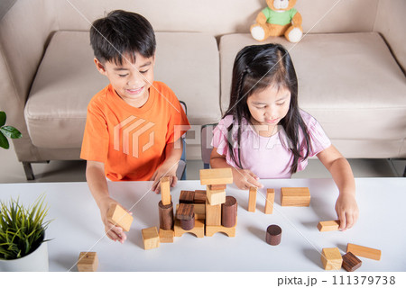 Children boy and girl playing with constructor wooden block building, Happy little kids play wood block stacking board game at home, activities learning creative, toys for preschool and kindergarten Children boy and girl playing with constructor wooden block building, Happy little kids play wood block stacking board game at home, activities learning creative, toys for preschool and kindergarten 111379738