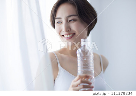 水を飲んでリラックスする若い女性 111379834
