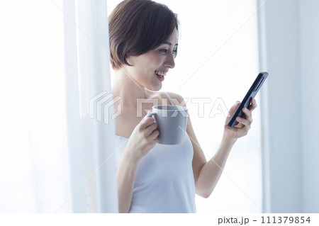 スマホを持ってリラックスする若い女性 スマホを持ってリラックスする若い女性 111379854