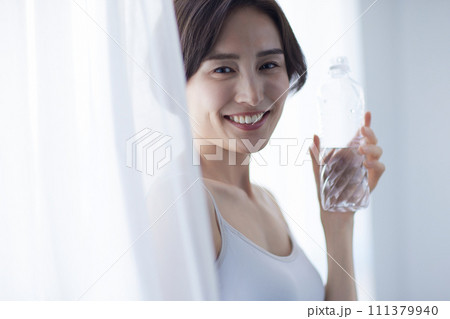 水を飲んでリラックスする若い女性 111379940