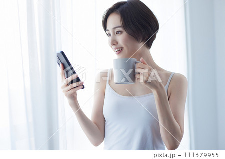 スマホを持ってリラックスする若い女性 111379955