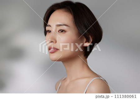 光と影の背景で撮影をした若い女性のスキンケアイメージ 111380061