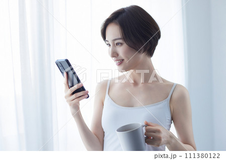 スマホを持ってリラックスする若い女性 111380122