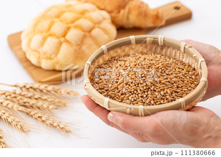 小麦を持つ女性の手とパン 111380666