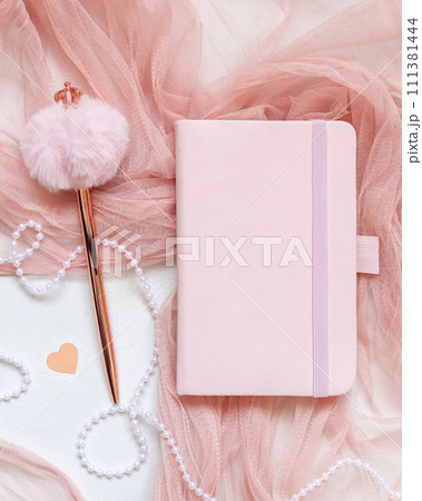 Pink hardcover notebook near hearts, pen, tulle and vase on white table top view, textbook mockup Pink hardcover notebook near hearts, pen, tulle and vase on white table top view, textbook mockup 111381444