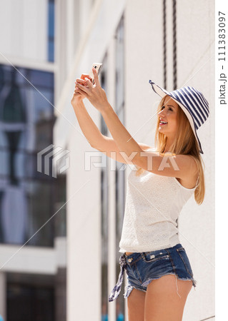 Young woman taking selfie with smartphone outside Young woman taking selfie with smartphone outside 111383097