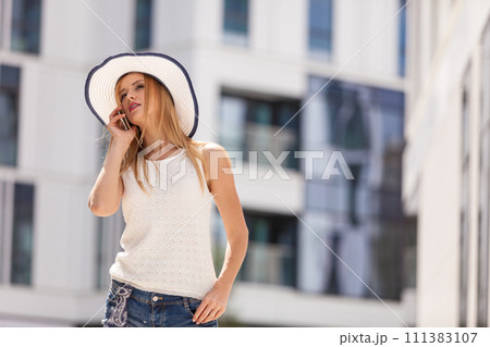 Young woman talking on smartphone outside 111383107