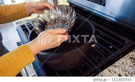 A steamed asparagus dish is being prepared in a modern white kitchen. A steamed asparagus dish is being prepared in a modern white kitchen. 111383353