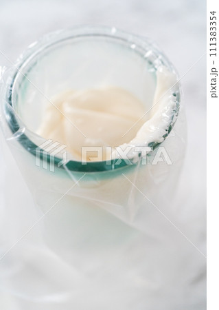 Transferring homemade royal icing into the piping bags for decorating sugar cookies. 111383354