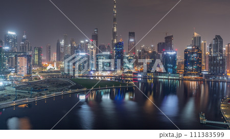 Aerial view to Dubai Business Bay and Downtown with the various skyscrapers and towers all night timelapse Aerial view to Dubai Business Bay and Downtown with the various skyscrapers and towers all night timelapse 111383599