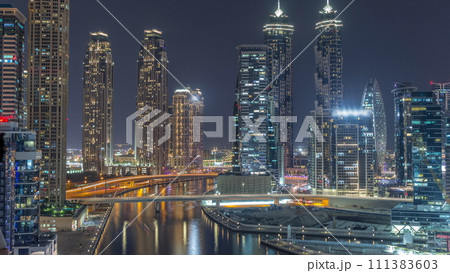 Cityscape with skyscrapers of Dubai Business Bay and water canal aerial day to night timelapse. 111383603