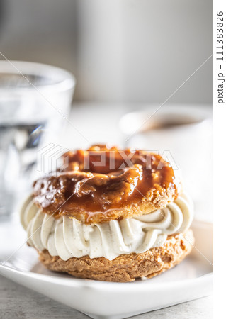 Veternik - sweet donut, typically Slovak caramel sweet cake with cream filling topped with caramel on a plate in a cafe Veternik - sweet donut, typically Slovak caramel sweet cake with cream filling topped with caramel on a plate in a cafe 111383826