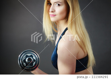 Fit woman lifting dumbbells weights 111384291
